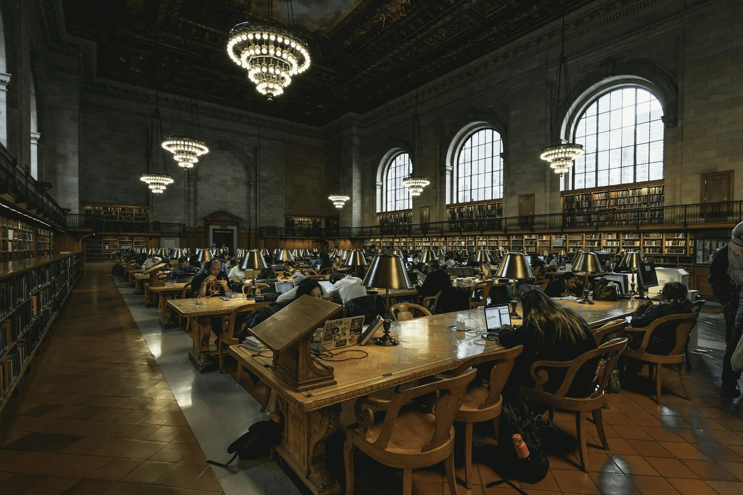 Large library reading room with desks and lamps